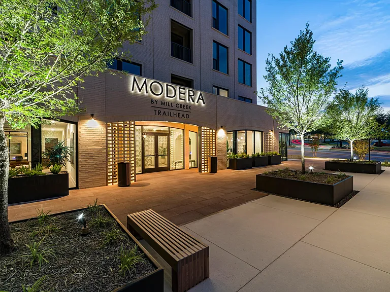 The warmly lit entrance at Modera Trailhead offers a refined welcome, setting the tone for an upscale living experience in Dallas.