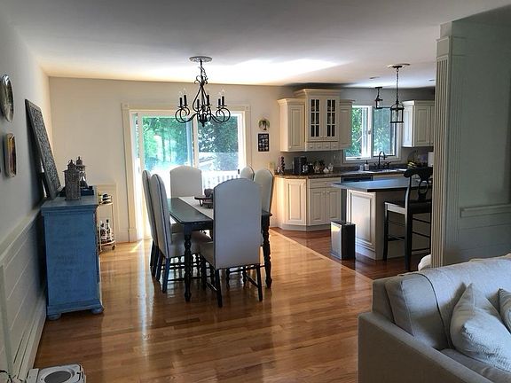 View from living room to dining and kitchen; sliders open to the deck