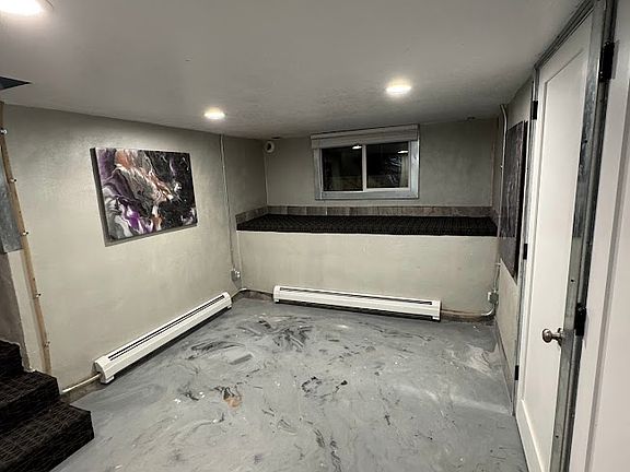 Living area with new front loader washer and dryer installed on bench by window not shown
