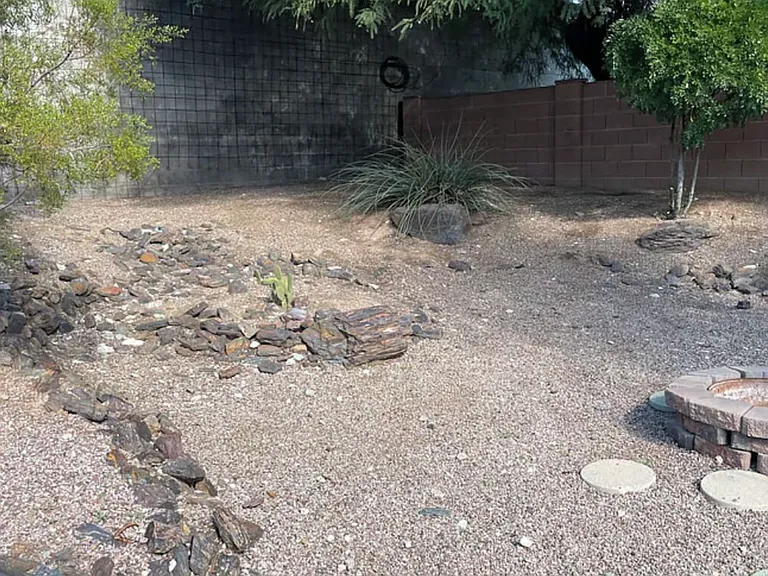 Fully enclosed, landscaped backyard with fire pit