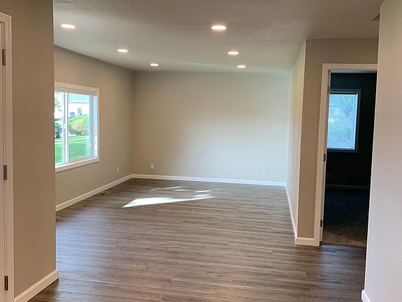 Large living area opens to kitchen, dining area, and hallway to bedrooms.