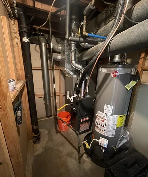 furnace room with new furnace and hot water heater