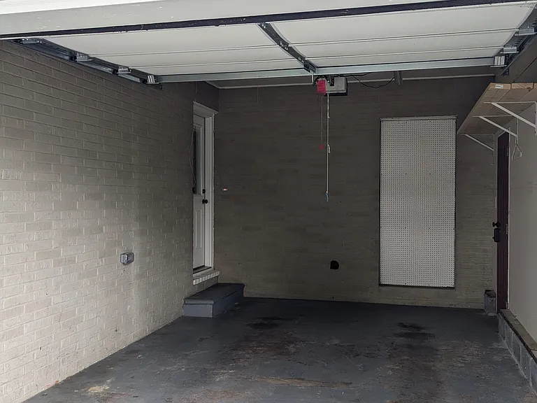 Single car garage with electric opener and entrance to home on the left and external access door on the right