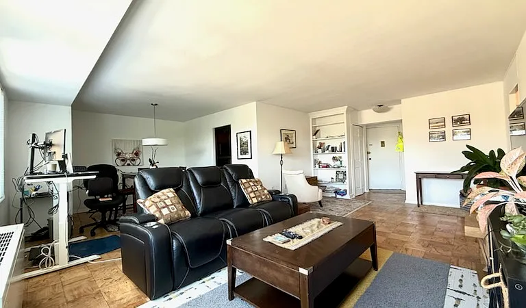 View of the living room, with the view of the front door and the built-in bookshelves.