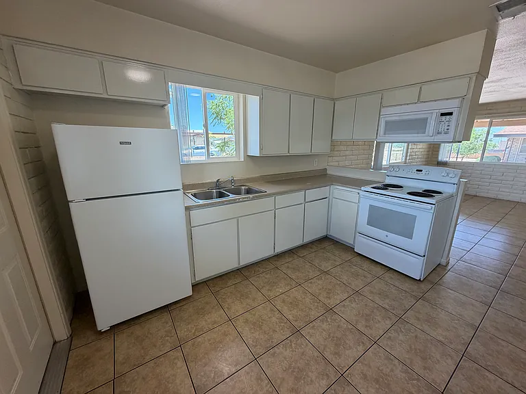Kitchen with full full size appliances including range, microwave and fridge.