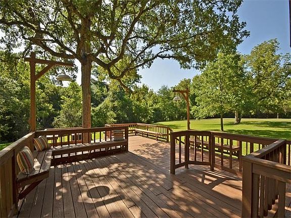 Large back deck, shaded by trees. This view faces the wet weather creek than runs along the back property line.