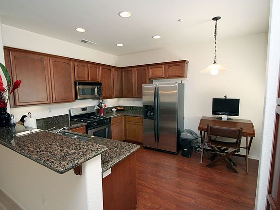 Kitchen with Granite counters, Stainless appliances and laminate flooring