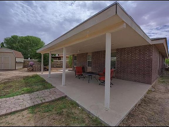 Back yard porch extends across the width of the house.