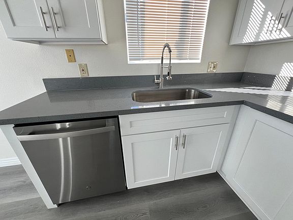 quartz countertops, stainless steel appliances including dishwasher, gas range and full size refrigerator