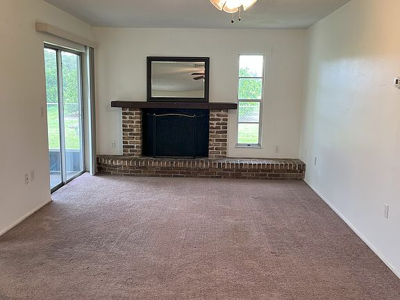 Living room with sliding glass door to screened lanai. Note fireplace is decommissioned due to insurance requirements.