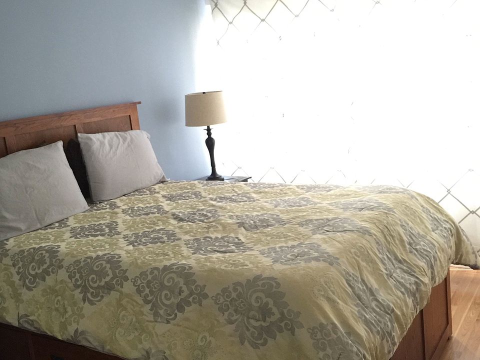 Queen Size bed w/frame and HDTV mounted on wall