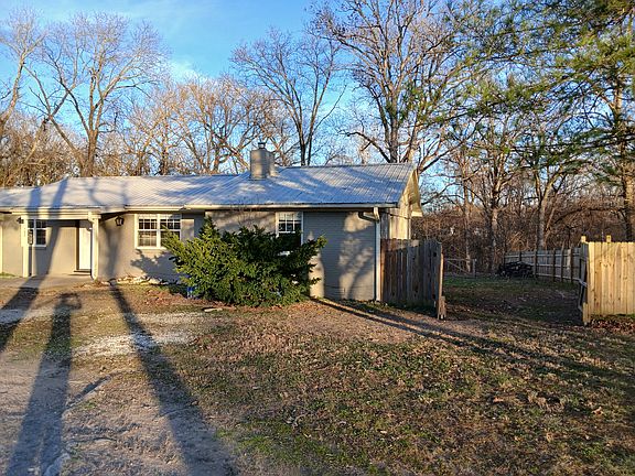 Front of residence and double wide backyard gate.