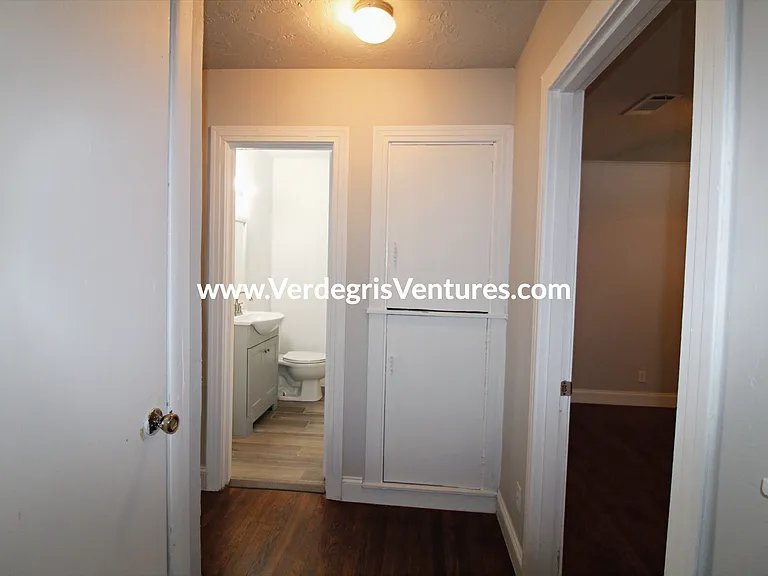 hallway includes built in cabinets and shelving for added storage