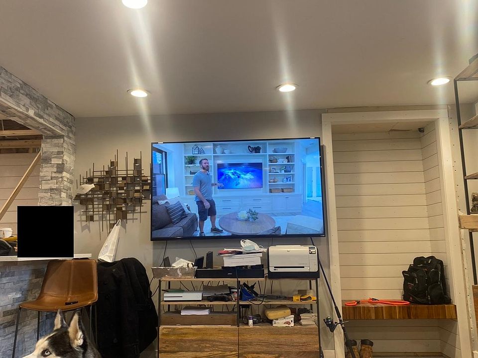 Spacious living room with a floating teak bench & shiplap mud room closet