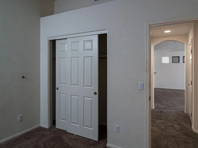 closet / wardrobe in office / guest bedroom; hallway and living room visible on right