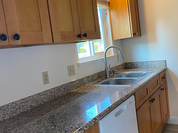 bright modern kitchen with stone countertops and vinyl plank floors