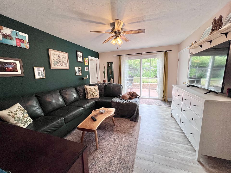 Living room. Doors open to patio and fenced in back yard. Other side opens to kitchen/dining area.
