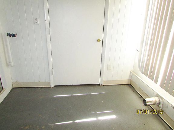 Lanai showing storage room where hot water tank is stored. Exhaust for dryer and water hookup for wash machine.