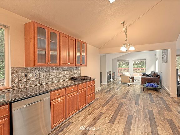 Kitchen leads to dining room area and family room with fireplace.