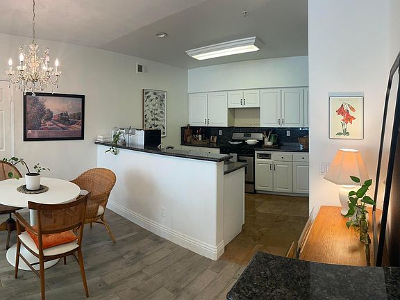 Built-in pony wall/entry shelf by door, dresser/mirror with storage space, dining area, and kitchen from the front door.