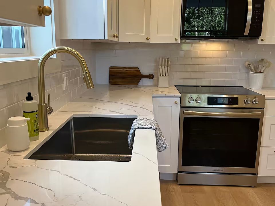 Quartz countertops, shaker cabinets, and large undermount sink.