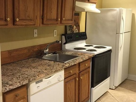 Kitchen area with full sized appliances including dishwasher