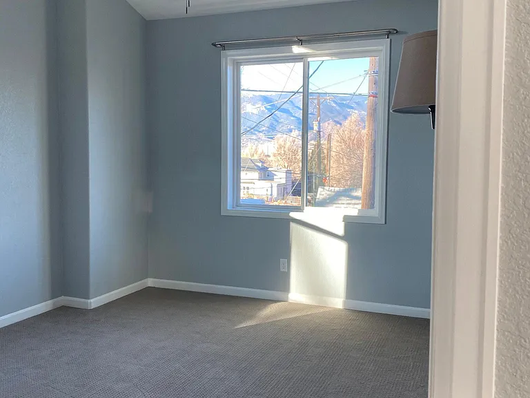 Large carpeted bedroom with great views and plenty of light. Blackout curtain rods are provided for lazy weekends or night owls.