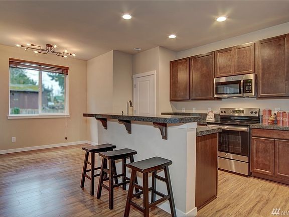Beautiful modern kitchen with step up island and counter seating. A dining nook with custom lighting for extra seating.  