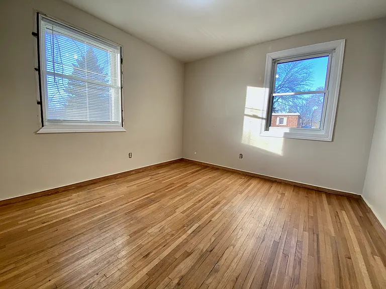 Bright and inviting room featuring polished hardwood floors, large windows with natural light, and a cozy ambiance. Bright and inviting room featuring polished hardwood floors, large windows with natural light, and a cozy ambiance.