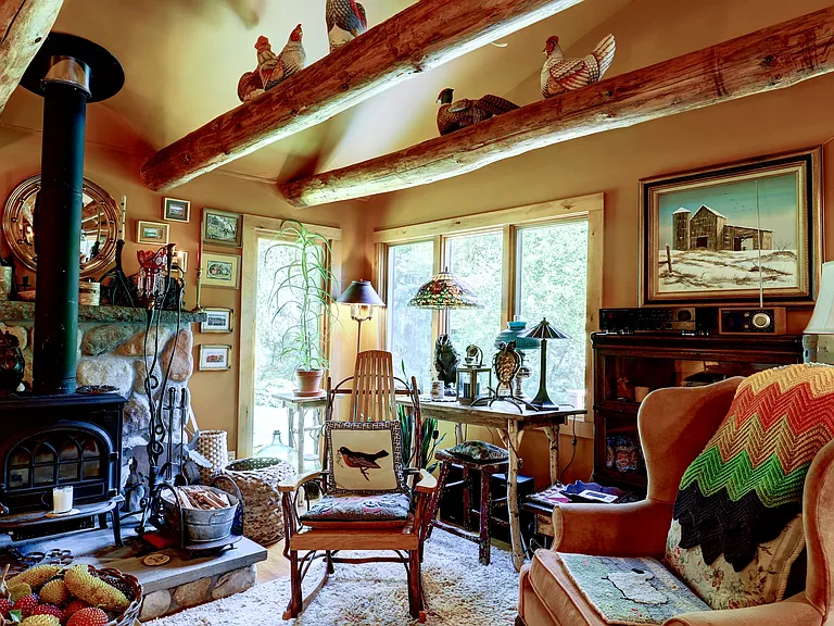 Living Area with Yotul wood stove, Twig and Adirondack furniture and winged back chair.