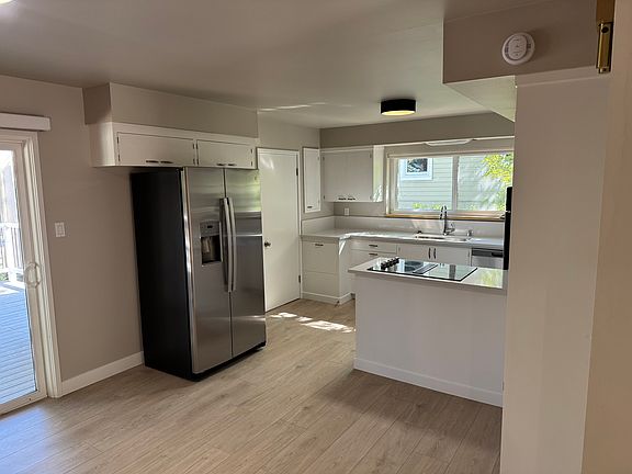Kitchen with all new appliances. Down draft electric kitchen aid cooktop. New quartz counter tops and faucet.