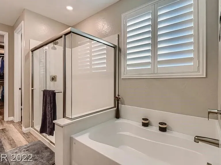 On-suite master bathroom with door to toilet room and closet in the background.