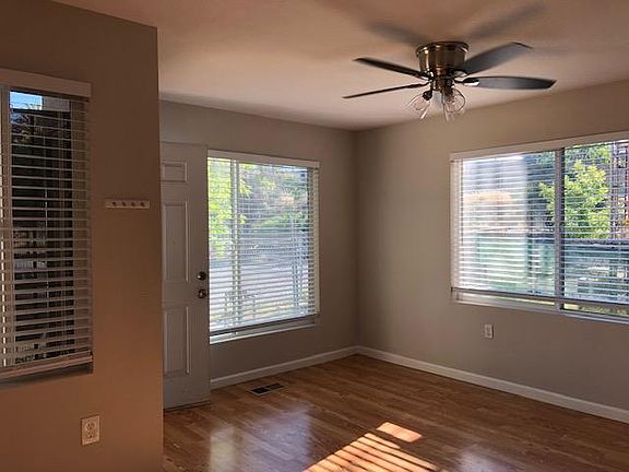 Enter into the living space with ample natural light through one large picture window, and two other windows. Wood laminate floors, two tone paint, faux wood blinds, LED ceiling fan.