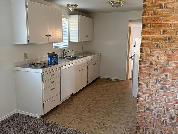 Kitchen with new dishwasher, fridge, and faucets.
