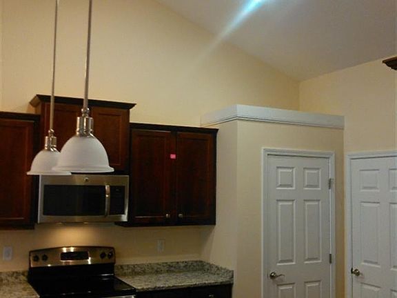 Gourmet Kitchen with granite tops, oversize sink, pull out faucet in brushed nickel, high with crown molding-- Maple Shaker style cabinets, hardwood flooring, pendant lighting over sink, pantry, laundry room off kitchen