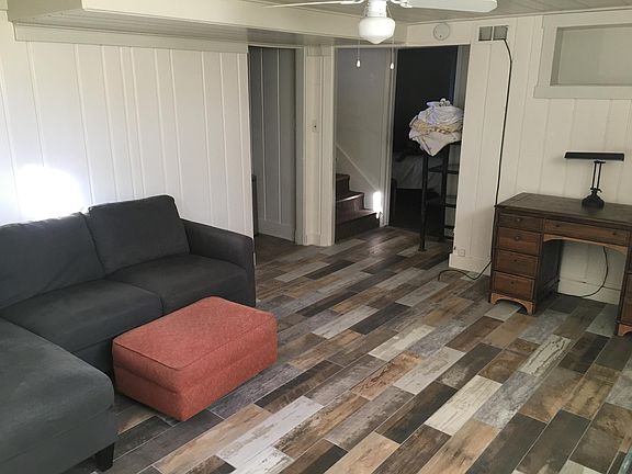 Living room, looking to stairs and bedroom, kitchen through doorway to the left.