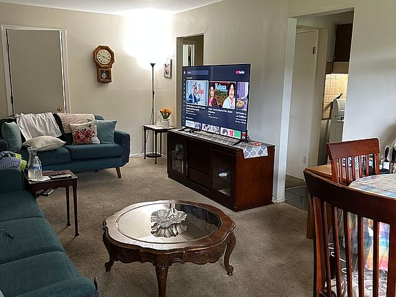 The living room features an open-concept design that seamlessly blends with the adjacent dining area, creating a sense of flow and connectivity.