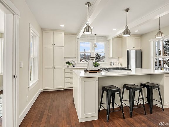 The kitchen island features an attractive and functional eating bar and provides additional storage. Access to the sunroom is directly to the left.