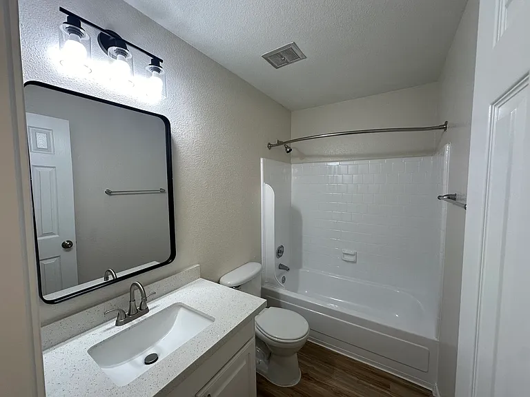 Bright and modern bathroom featuring a sleek vanity, stylish mirror, and elegant lighting. Bright and modern bathroom featuring a sleek vanity, stylish mirror, and elegant lighting.