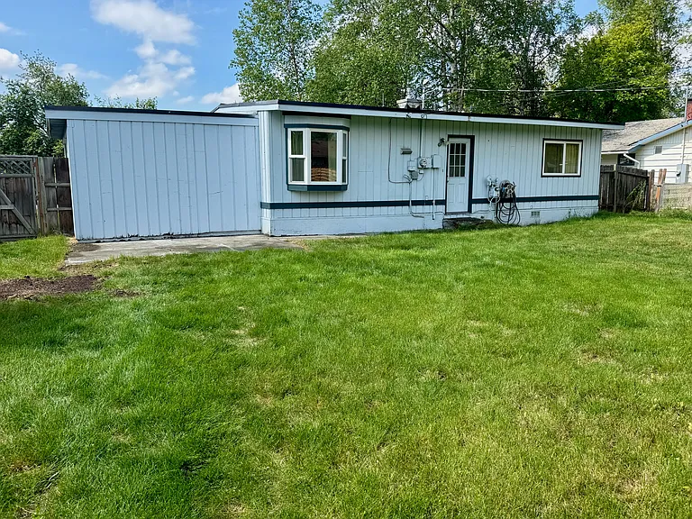 View of back of house with bay window from dining room, back door, and east-facing bedroom window.