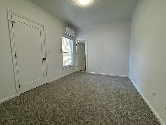 Spacious, freshly painted bedroom featuring new carpeting and a mini-split system for energy-efficient heating and cooling.