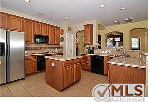 Inviting kitchen with corian type counters, black appliances, 42