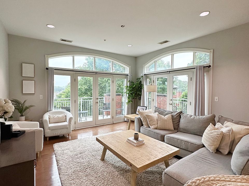 A light-filled living area with large arched windows and multiple French doors leading to the wrap-around balcony. The spacious layout and high ceilings provide a welcoming and open feel, ideal for both everyday living and entertaining.