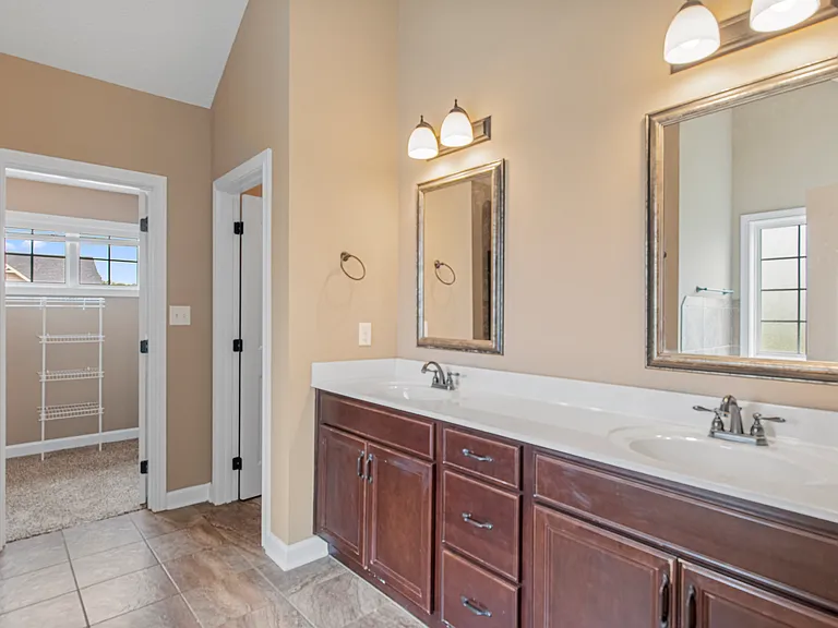 Double vanity Master Bath with expansive, under-sink storage, water closet, and a huge walk-in closet
