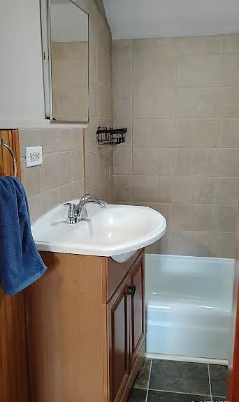 Medicine cabinet mirror opens above charming vanity with outlet, so functional.