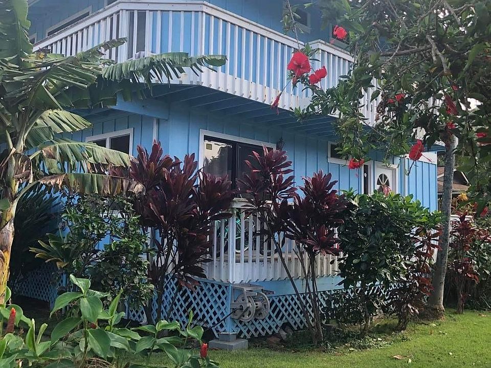 Corner view of house. Upper and lower balconies. Upper balcony is ideal place to hang a hammock under the stars. Tropical landscaping with lots of fruit trees.