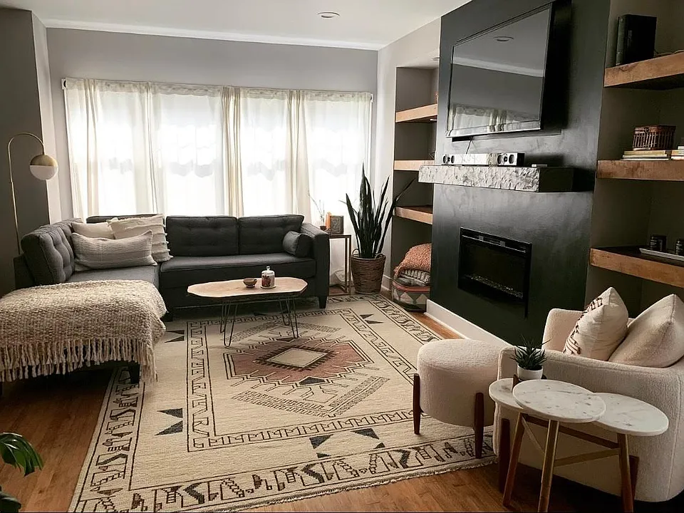 Living room with built in shelving and electric fireplace.