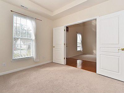 Main level home office with trey ceiling and double doors for privacy