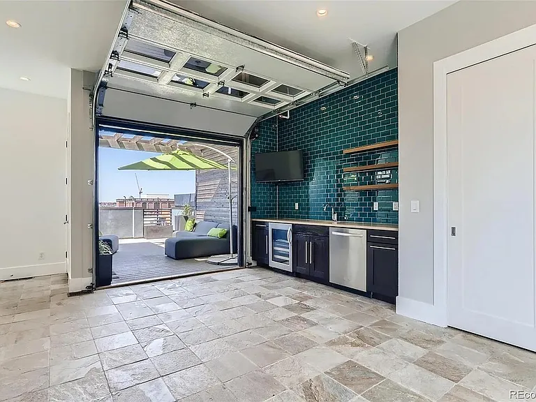 roof area with full wet bar, wine fridge, dishwasher, storage and full size garage door opening to large roof deck (room for seating area, small dining area, and lounge chairs)