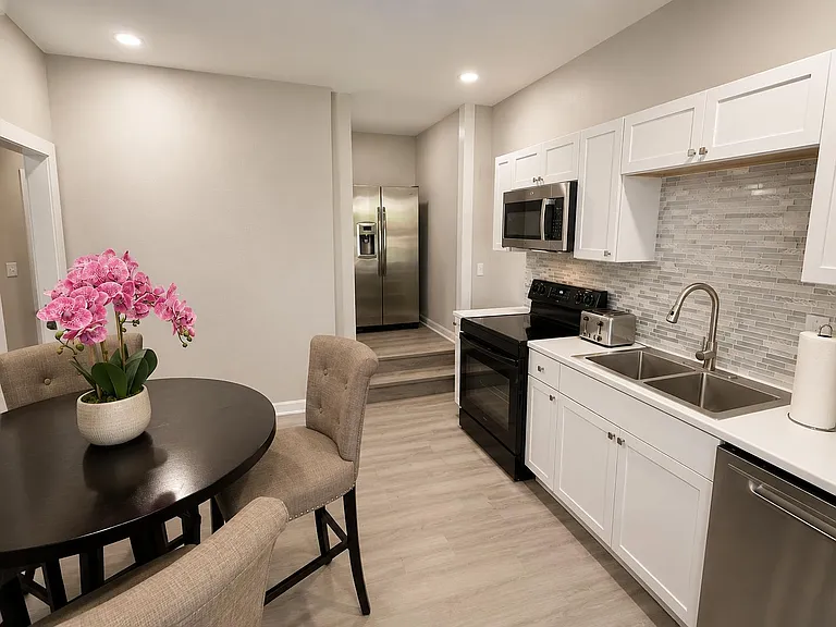 Updated kitchen with shaker cabinets, tile backsplash, stainless appliances, and an adjacent dining nook for everyday meals.